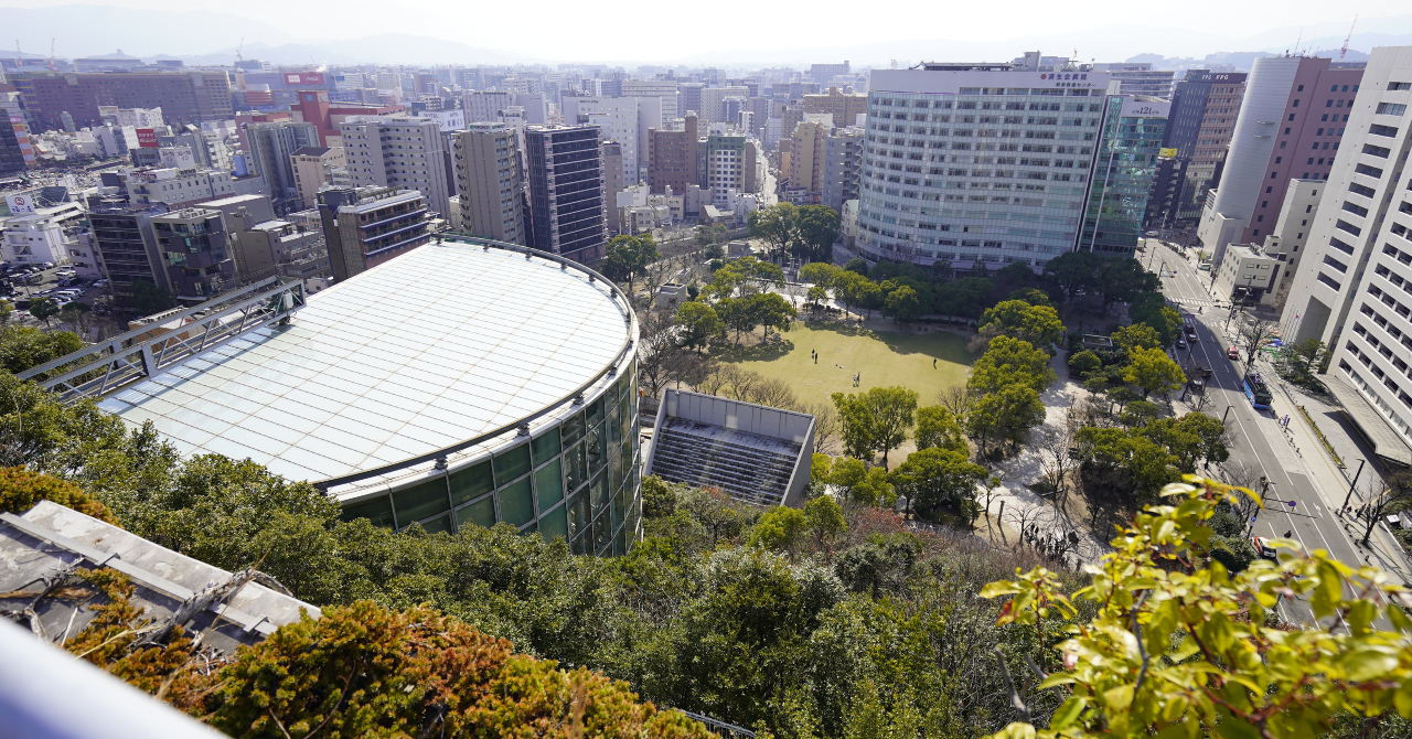 アクロス福岡屋上から見下ろす円形ホールの屋根と天神中央公園、周囲に広がる天神の街並み