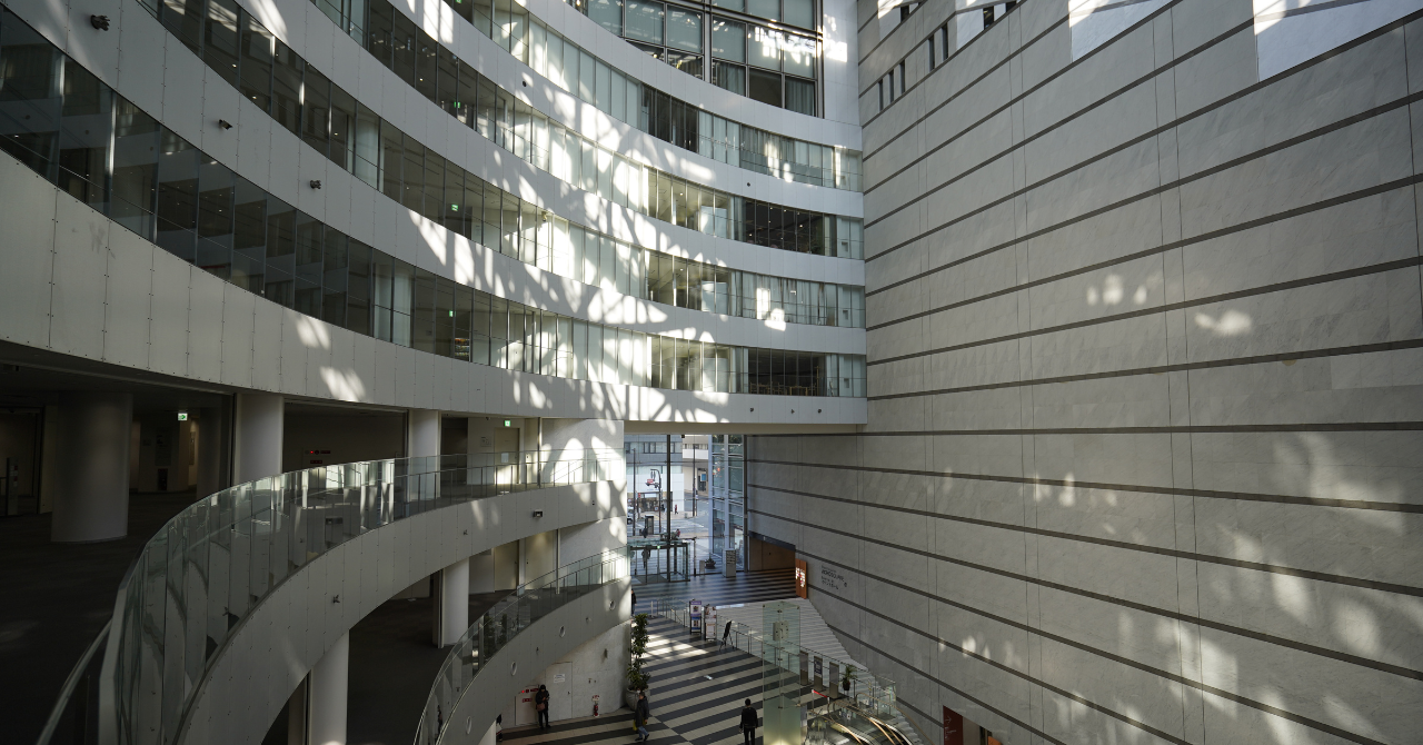 自然光が差し込むアクロス福岡の館内吹き抜け空間と曲線的な回廊デザイン