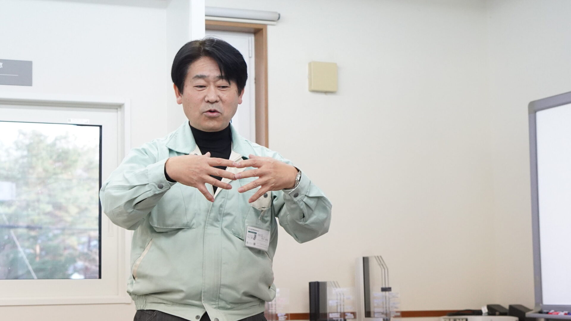 樹脂サッシの構造や断熱性能について工場担当者が説明している様子