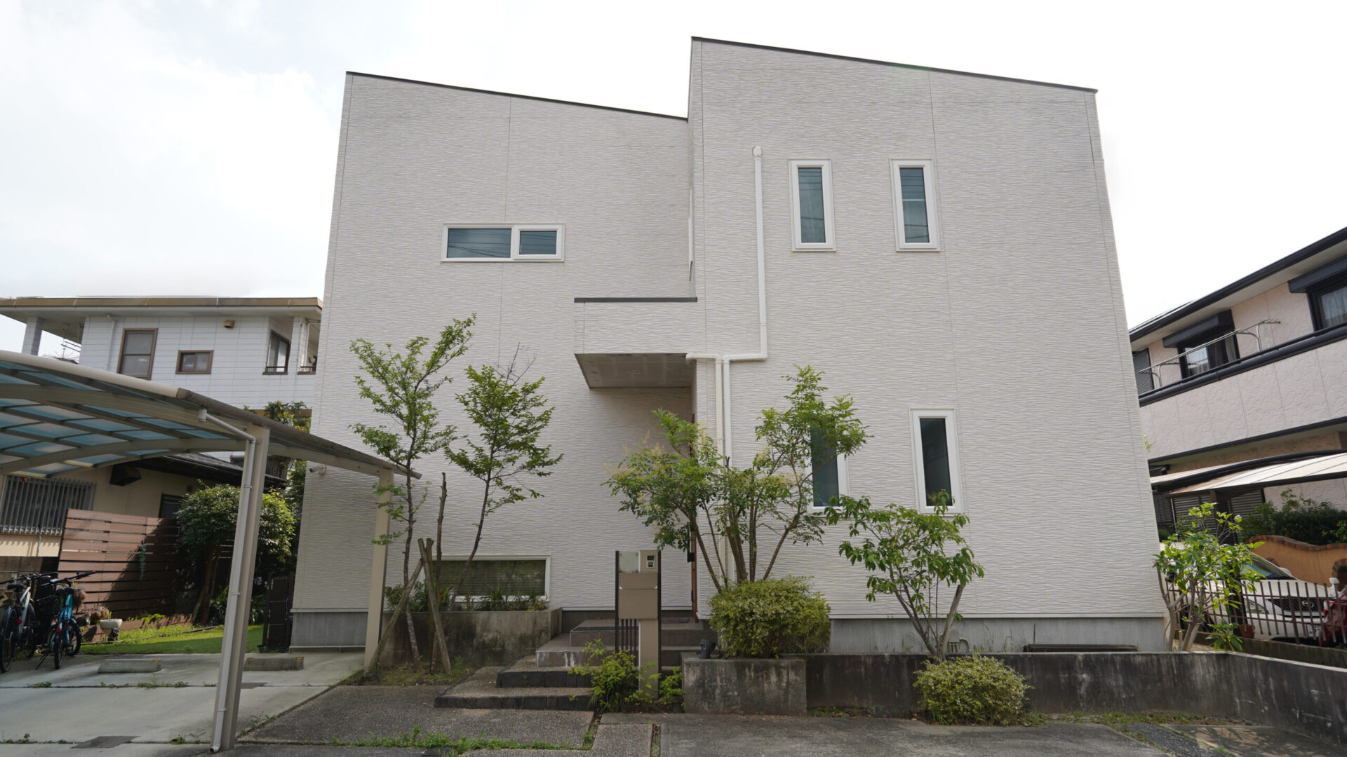 コーキング劣化や苔が目立っていた、外壁リフォーム前の白い外観