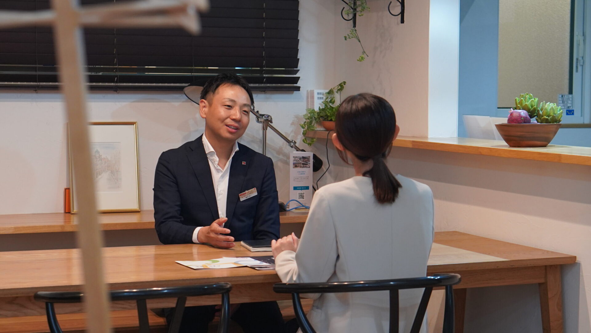 木のカウンターを挟んで会話する藤田所長と大塚さん。キッチンと暮らしの未来について語り合う様子