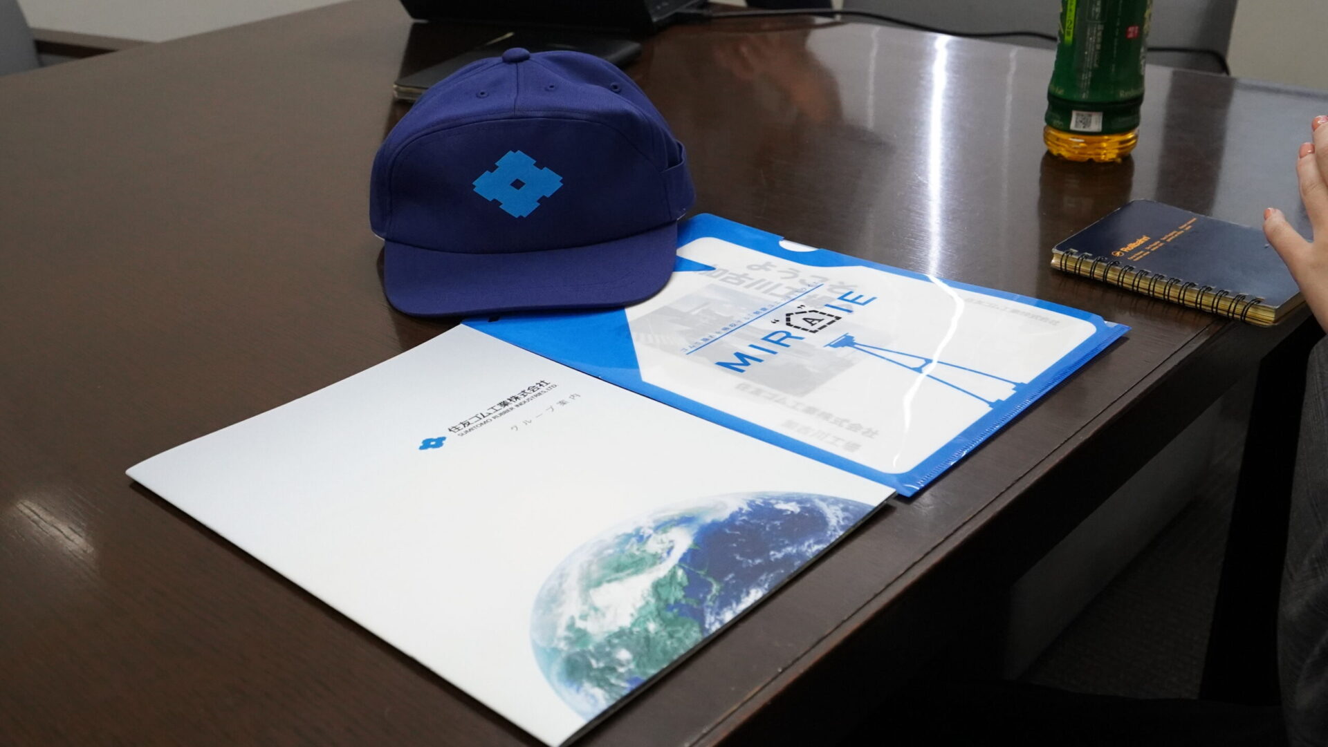 住友ゴム工業の制振ダンパーMIRAIEの資料とキャップが並ぶ対談インタビュー準備中のテーブル風景