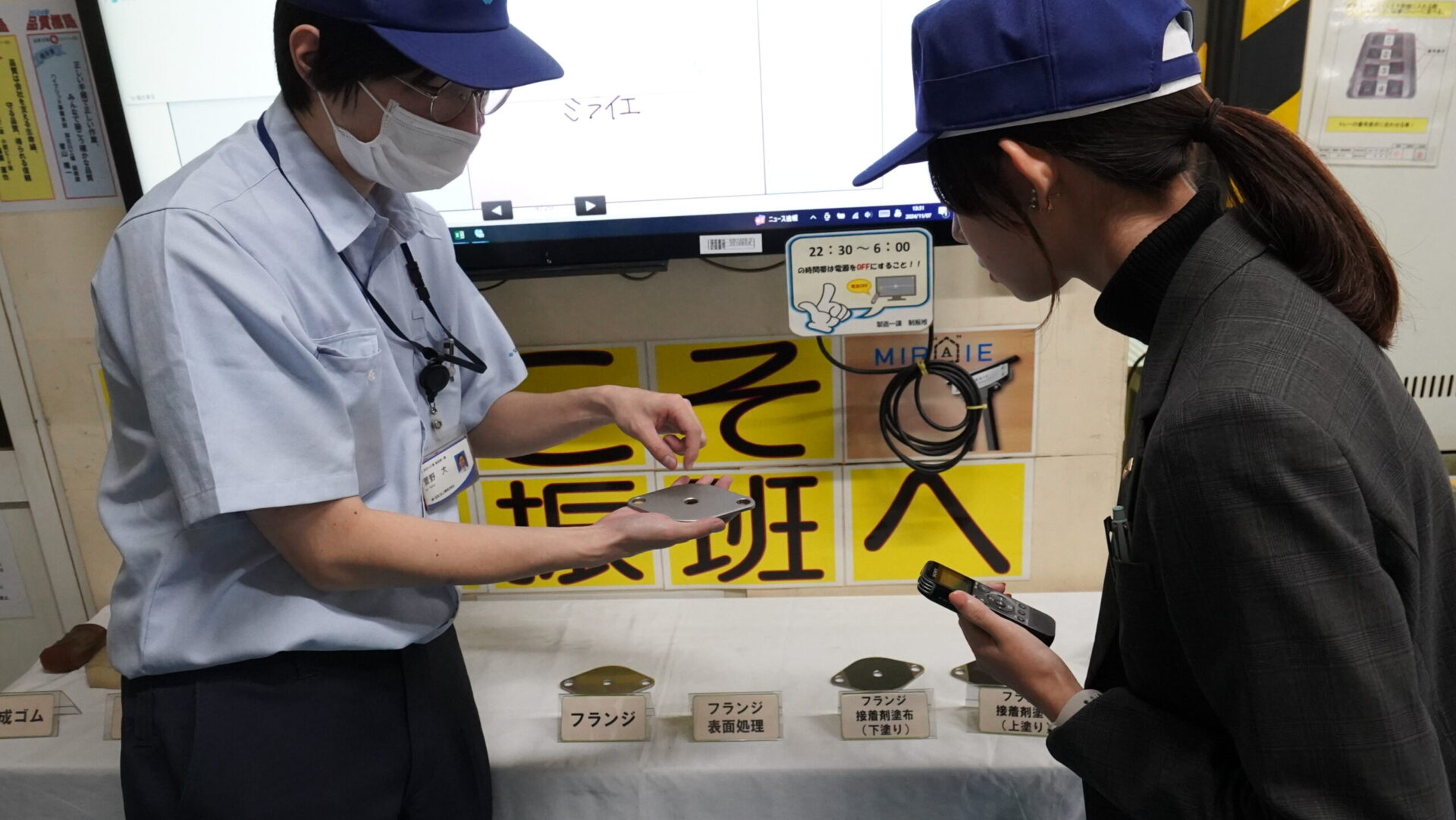 高減衰ゴムと金属部材を組み合わせる接着工程について説明を受ける工場見学の場面