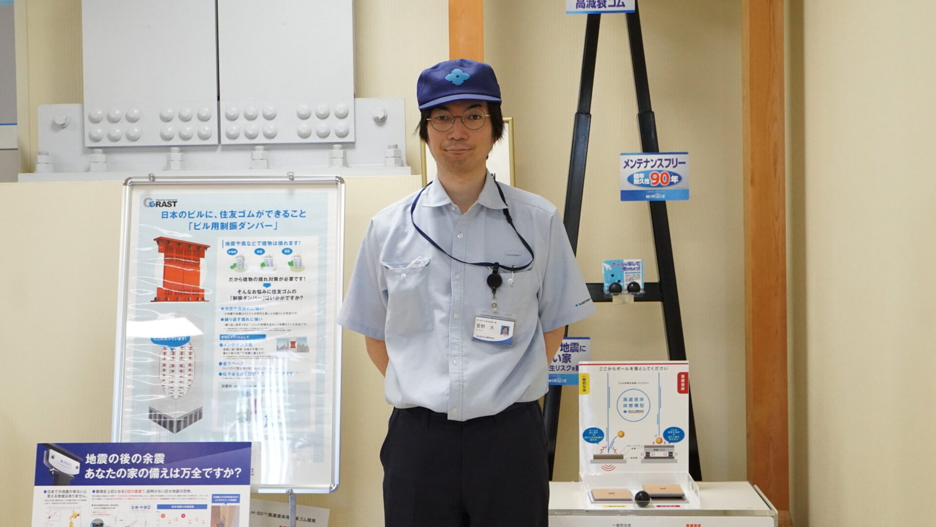 住友ゴム工業の制震技術と建物を守る仕組みを紹介する展示の前に立つ製造担当者