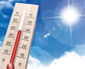 強い日差しの下で気温が高くなる夏の暑さを示す温度計