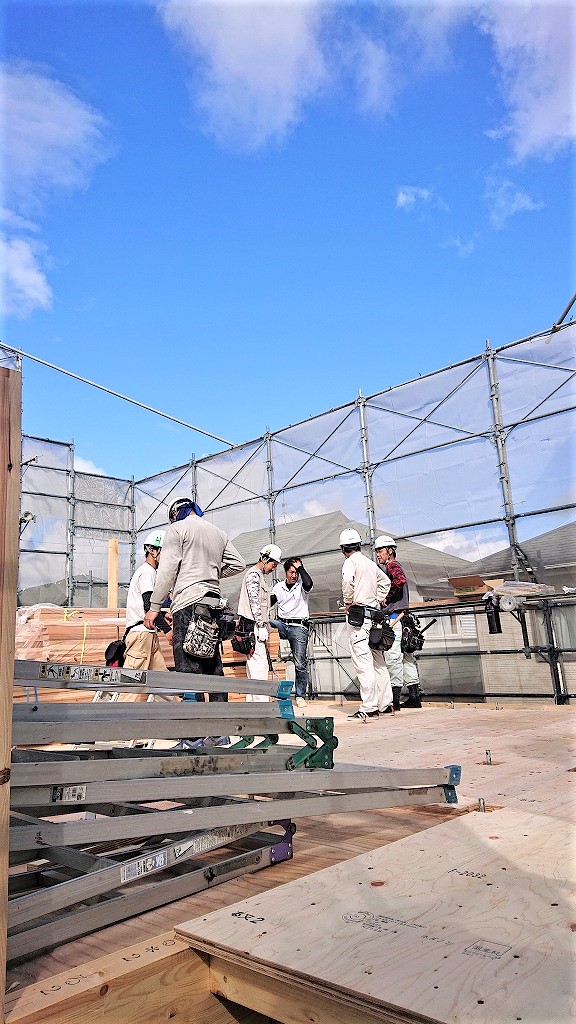 建て方初期段階の床上で作業内容を確認する職人たちの打ち合わせ風景