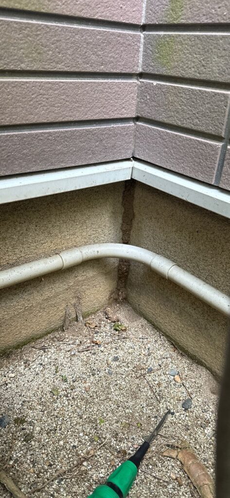 外壁基礎の角に見える縦に走る白蟻の通り道（蟻道）