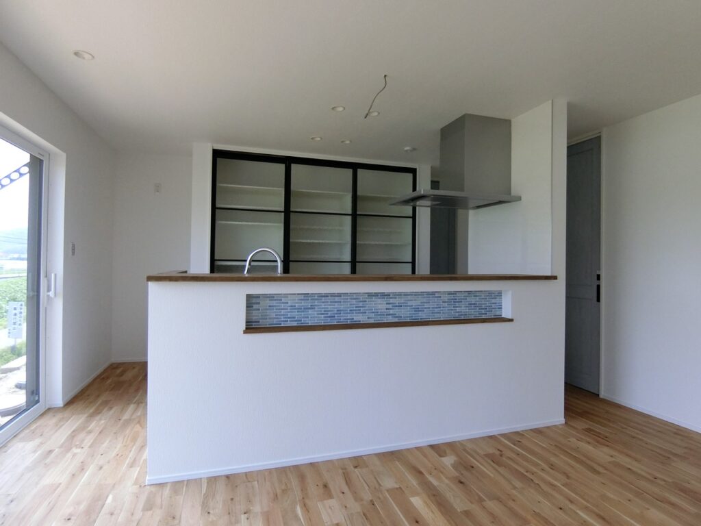 キッチンカウンターの腰壁に設けられた、ガラスタイルがアクセントのニッチ