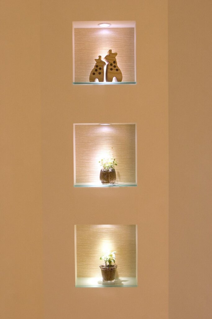 縦に3つ並んだ照明付きニッチに、植物とオブジェが飾られている壁面ディスプレイ