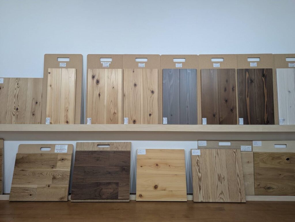 色や木目が異なる無垢材のサンプルが上下2段に整然と並べられた展示棚