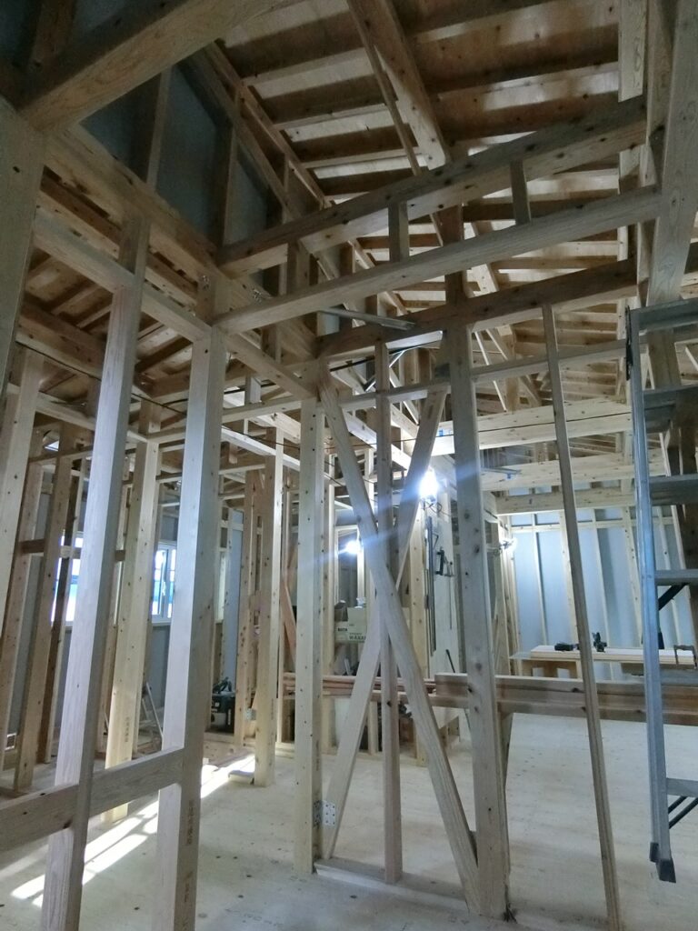 住宅建築中の木造構造体に使われたひのき材の柱や梁が組まれた現場内部