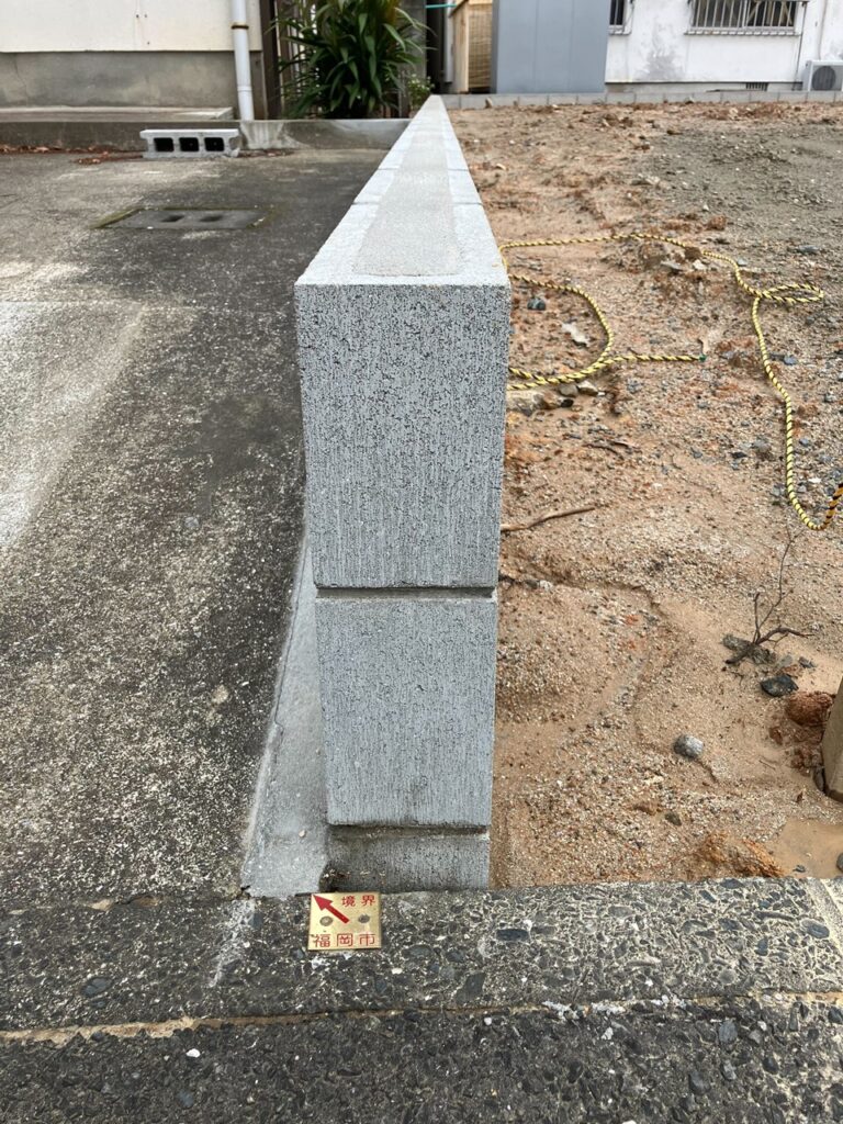 福岡市の境界プレートと隣接するブロック塀の近接写真