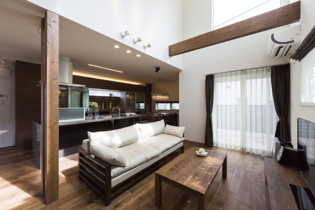 光沢感のある木の床が高級感を演出する、ウレタン塗装仕上げの濃色の木の床とリビング・キッチン空間