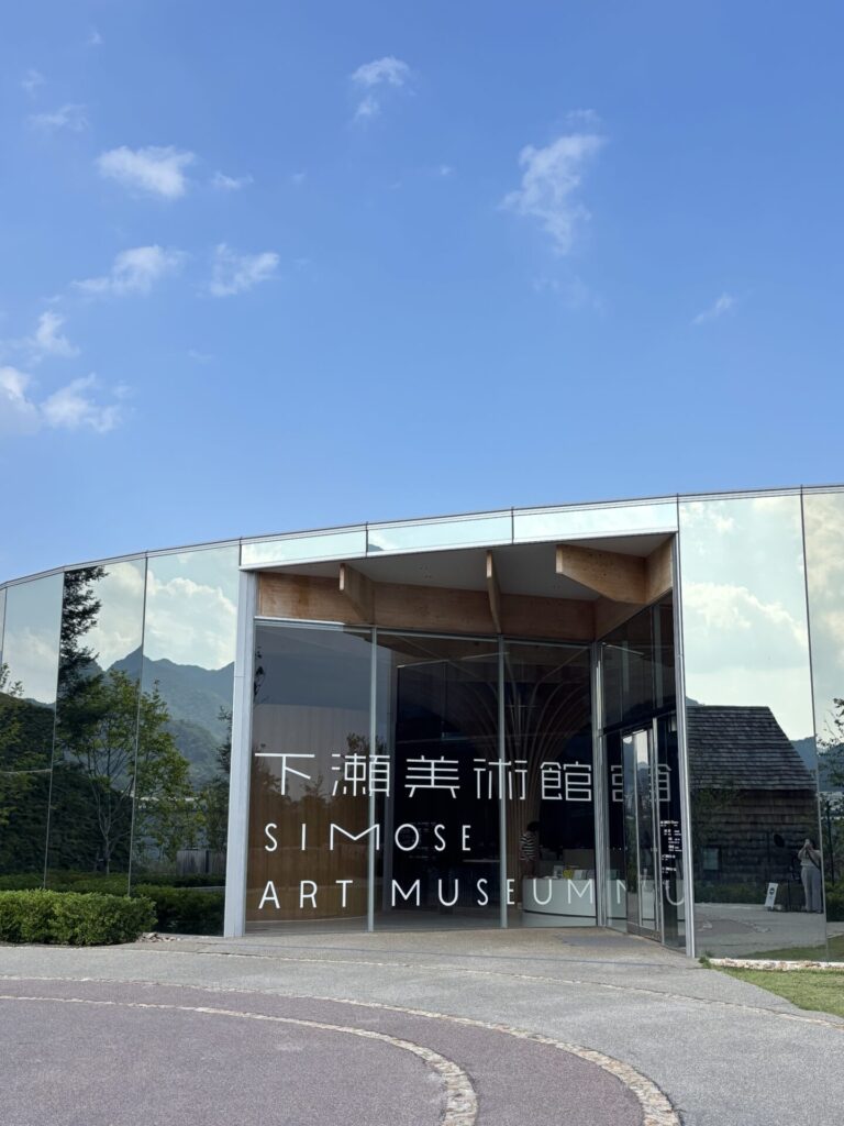 ミラーガラス外壁に周囲の風景が映り込む、下瀬美術館のエントランス外観