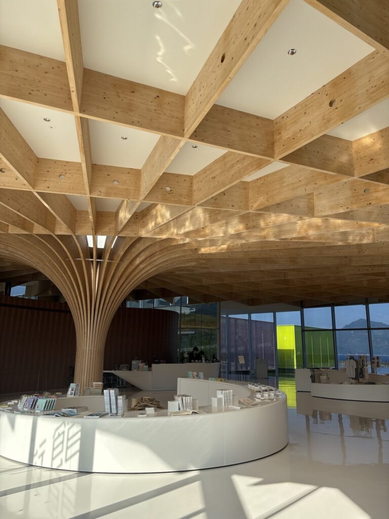 木格子天井と曲線カウンターが広がる、下瀬美術館の開放的なエントランス内観