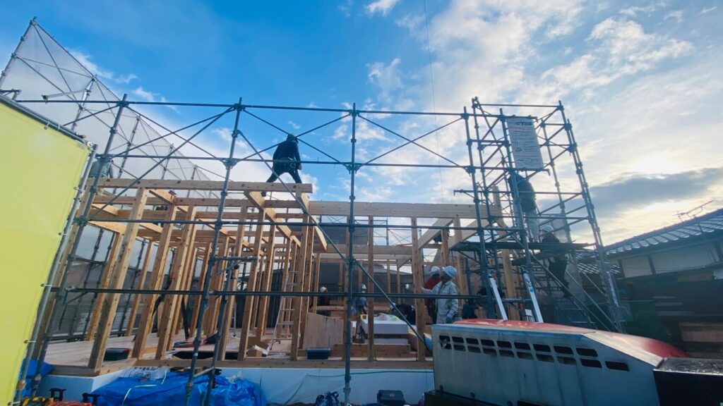 建て方作業中に柱と梁を組み上げる木造住宅の工事現場の様子