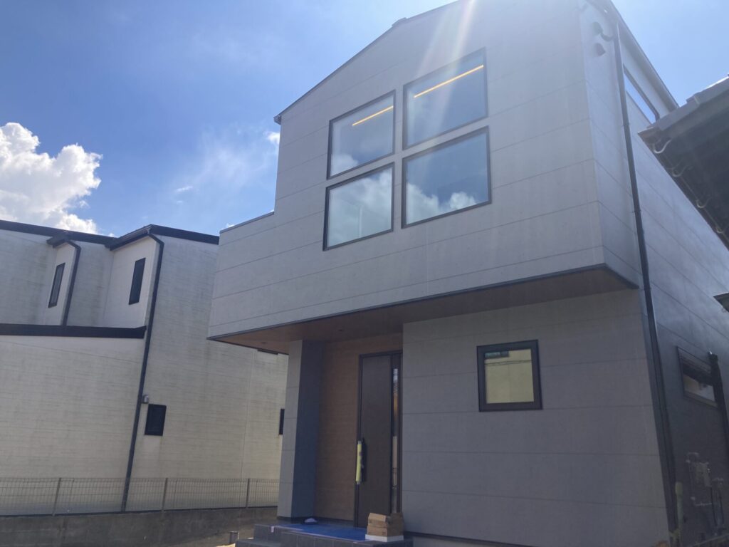 外部足場が外れ完成間近となった注文住宅の外観と青空の風景