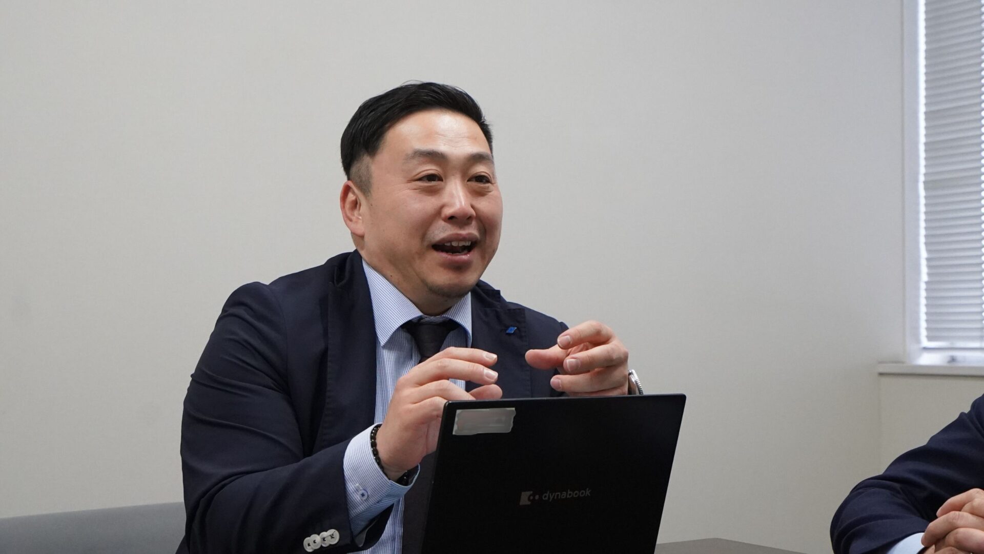 住友ゴム工業の社員が、製品や取り組みについて取材チームに説明する場面